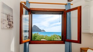Ein Zimmer mit großem Fenster, einem Bett und einem Wandbild.
