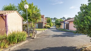 A residential street with houses, a lamp post, and a bicycle.