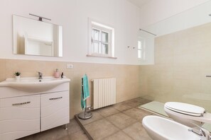 A bathroom with a sink, mirror, window, radiator, and toilet. - Il Geosito - Camera tripla (Gallipoli)