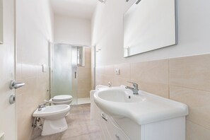 A modern bathroom with a toilet, bidet, and sink. - Il Geosito - Camera quadrupla standard (Gallipoli)