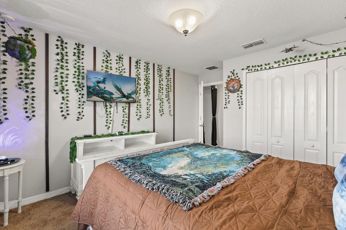 Une chambre à coucher avec un lit, une télévision, une commode blanche et une armoire.