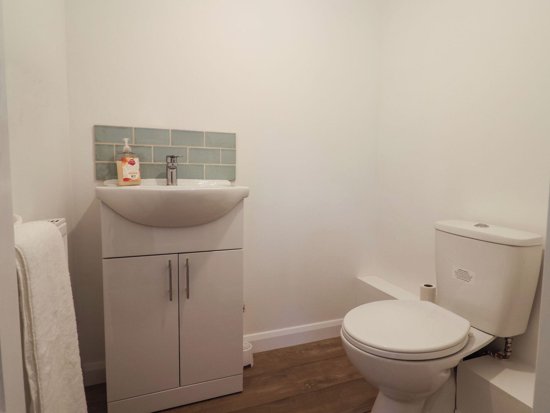 Een badkamer met een wit wastafel, toilet en kast.