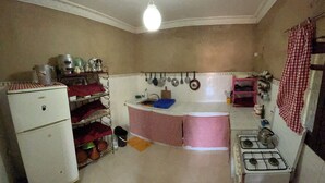 A compact kitchen with a refrigerator, sink, stove, and various utensils. - Lake view, comfortable artistic design (Ouirgane)