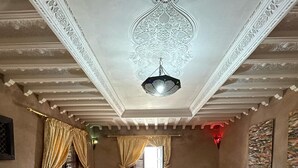A traditional room with a sofa set, a patterned rug, and a hanging light fixture. - Lake view, comfortable artistic design (Ouirgane)