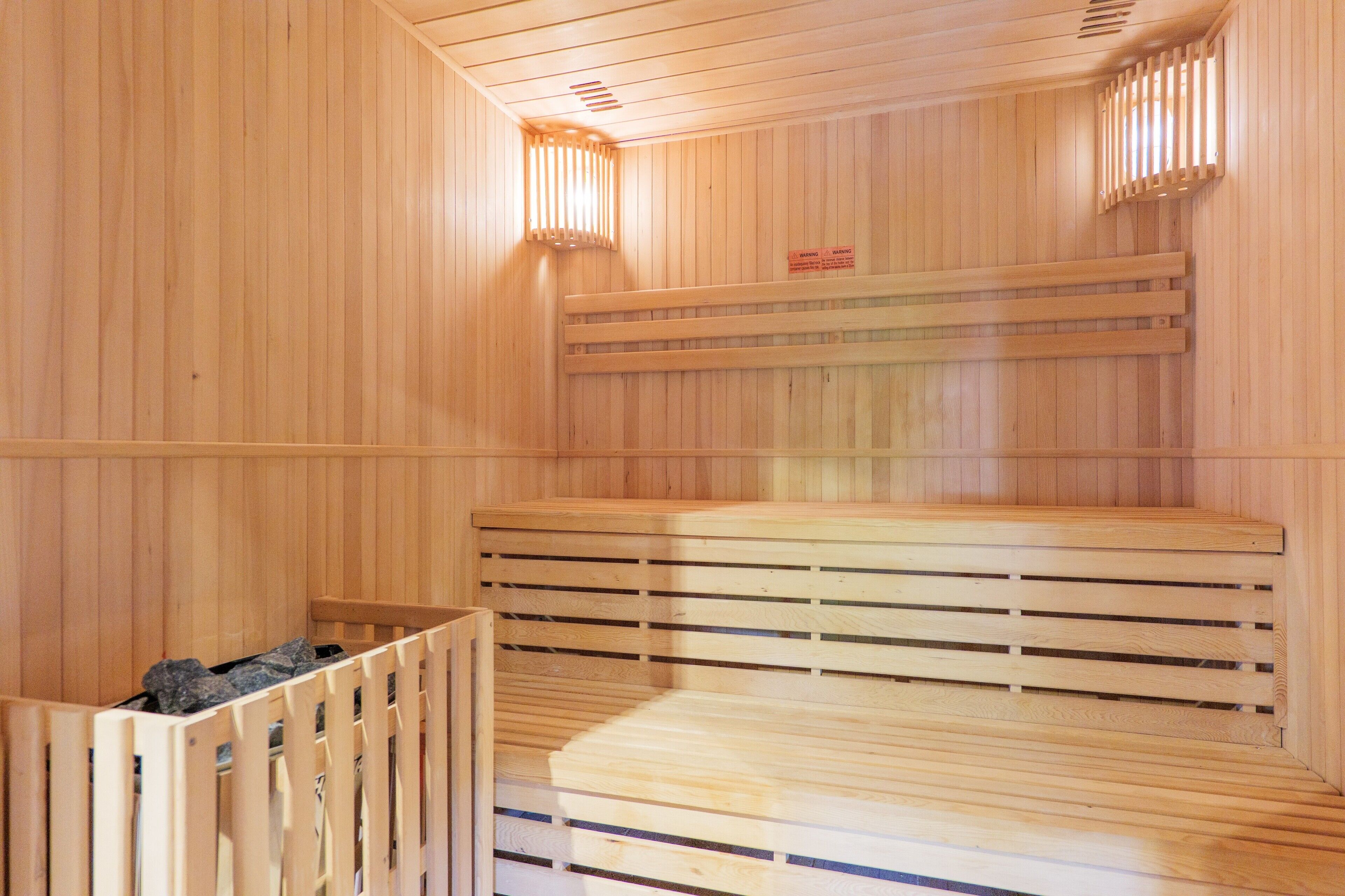 A sauna with wooden benches and a bench with a backrest.