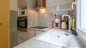 Una cocina compacta equipada con microondas, horno y lavamanos.