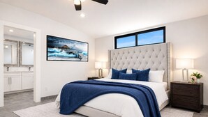 Une chambre moderne avec un grand lit, une tête de lit, deux tables de chevet avec des lampes, une commode, une grande fenêtre et un tableau au mur.