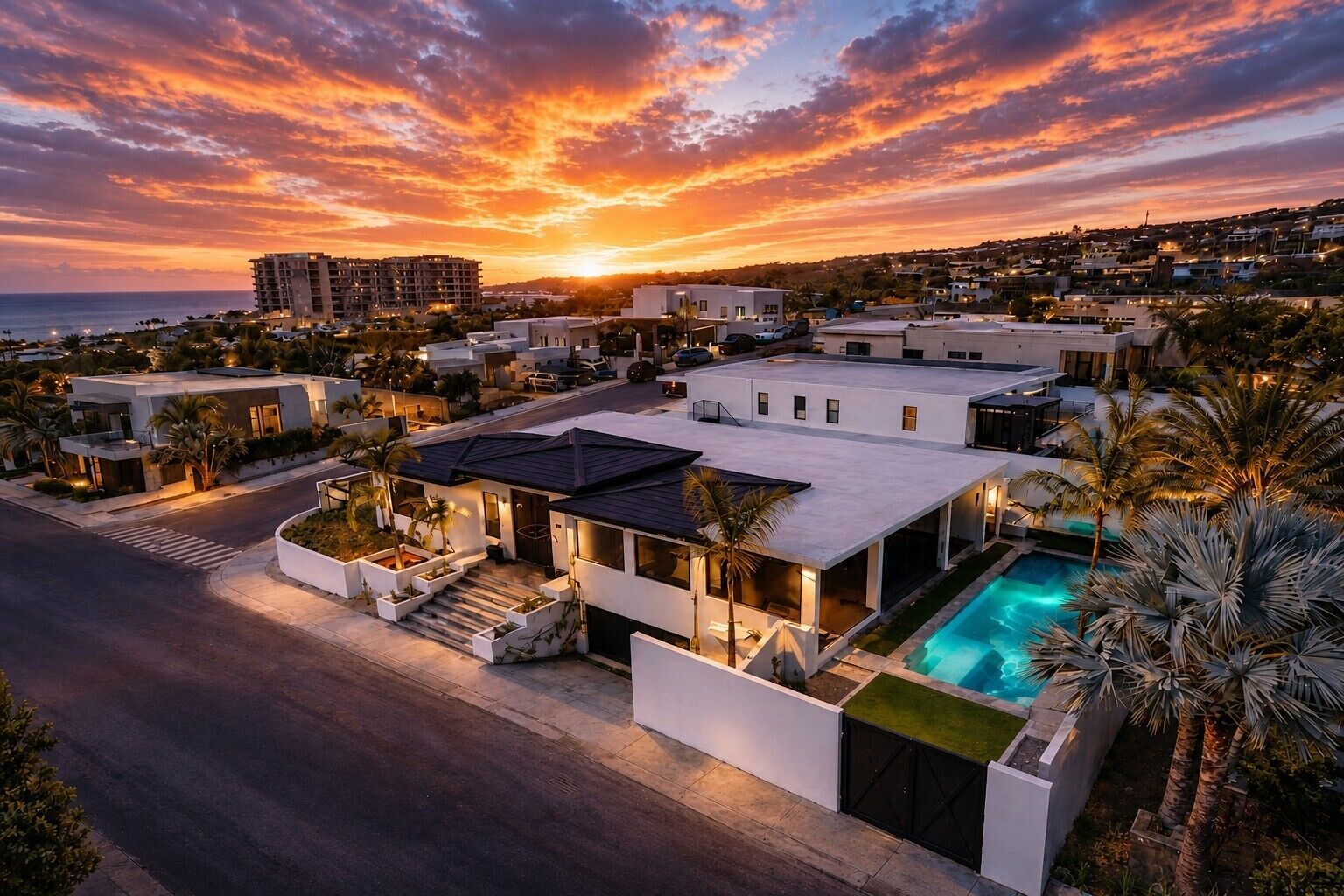 Un quartier résidentiel avec des maisons modernes, une piscine et une vue sur le coucher de soleil.