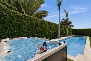 Une piscine avec un jacuzzi et une coupe de champagne.