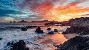 Un paisaje costero con formaciones rocosas y un atardecer.