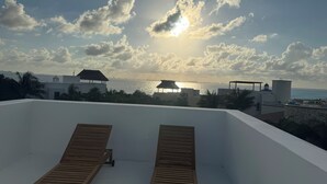 A rooftop terrace with two wooden loungers, a view of the sea, and a sunset. - ROOF TOP & PRIVATE JACUZZI
VILLAS MAR TURQUESA (Isla Mujeres)