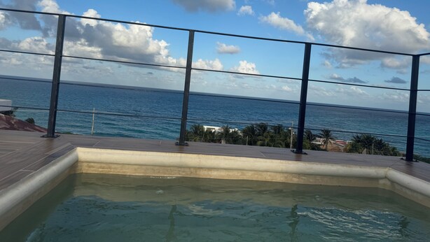 A pool with a view of the ocean and a clear sky. - ROOF TOP & PRIVATE JACUZZI
VILLAS MAR TURQUESA (Isla Mujeres)