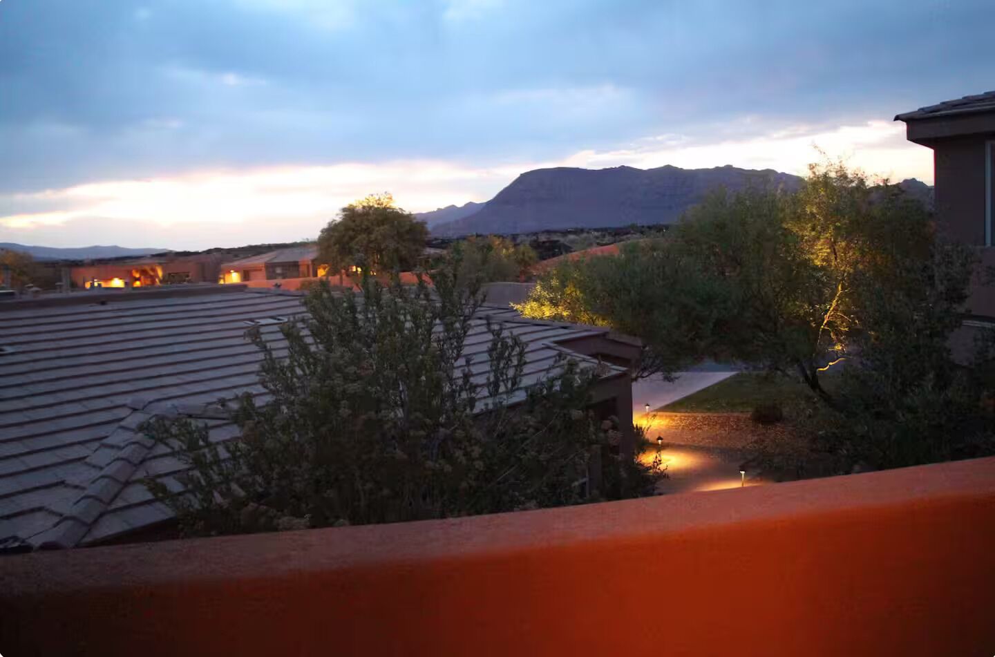 Zona residencial con casas, una montaña al fondo y cielo despejado.
