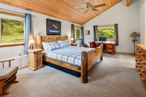 A bedroom with a wooden bed, a desk, a chair, and a view of greenery outside. - Cle Elum Lake Cabin w/ Hot Tub & Game Room (Ronald)