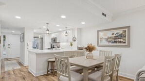 A modern kitchen with white cabinetry, a central island, and pendant lighting. - Lowcountry Luxury,Updated Shipyard Townhouse, Steps to Pool, 8 Min Walk to Beach, Grill, Golf View (Hilton Head Island)