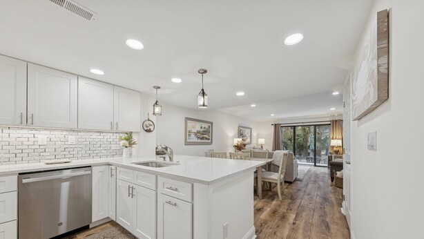 A modern kitchen with white cabinetry, a central island, and recessed lighting. - Lowcountry Luxury,Updated Shipyard Townhouse, Steps to Pool, 8 Min Walk to Beach, Grill, Golf View (Hilton Head Island)