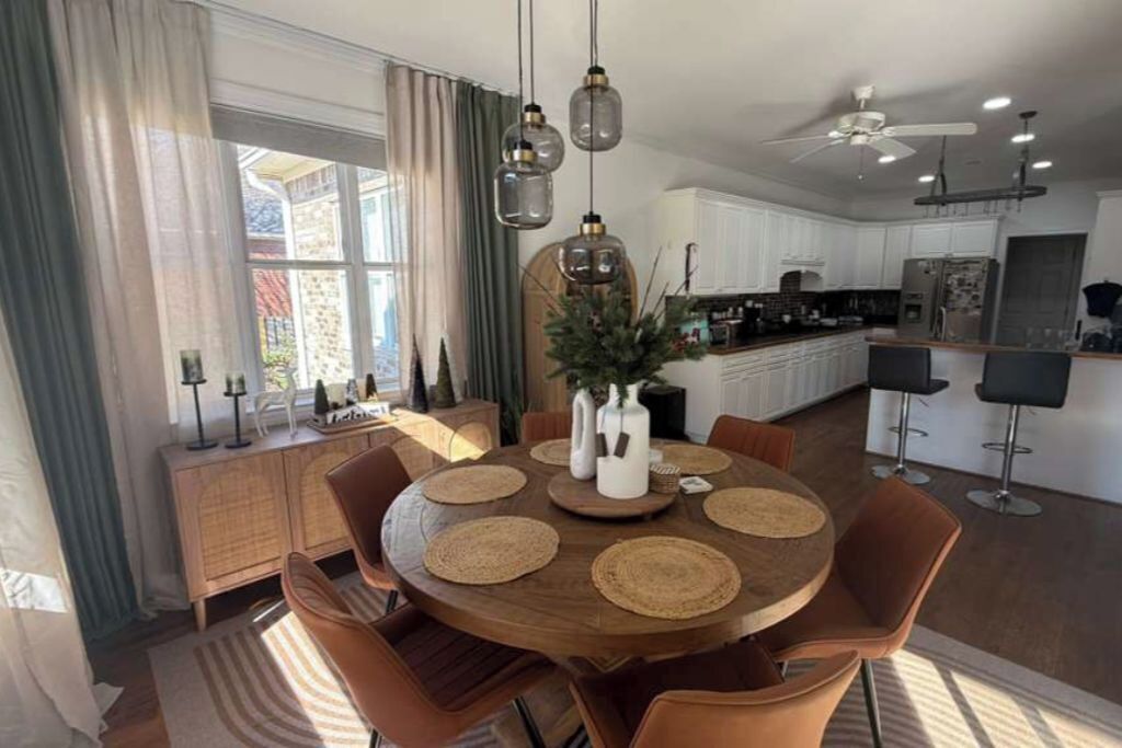 Une cuisine moderne avec des meubles blancs, un îlot central et des luminaires suspendus.