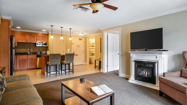 A living room with a fireplace, a television, and a dining area with chairs and a table. - 2BR/2BA South Mountain Condo – Fireplace, Pool, Near Loon Ski Area (Lincoln)