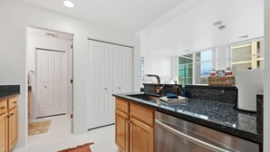 Una cocina moderna con refrigerador de acero inoxidable, gabinetes de madera y encimera de granito.