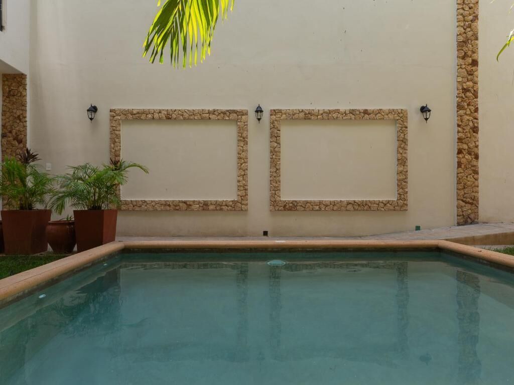 Ein Pool mit Steinverzierungen und Pflanzen in Töpfen.