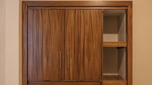 A wooden wardrobe with two doors, a shelf, and a hanging space. - Hotel bernardino (Valladolid)