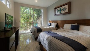 A hotel room with two beds, a TV, and a balcony with a view of trees. - Hotel bernardino (Valladolid)