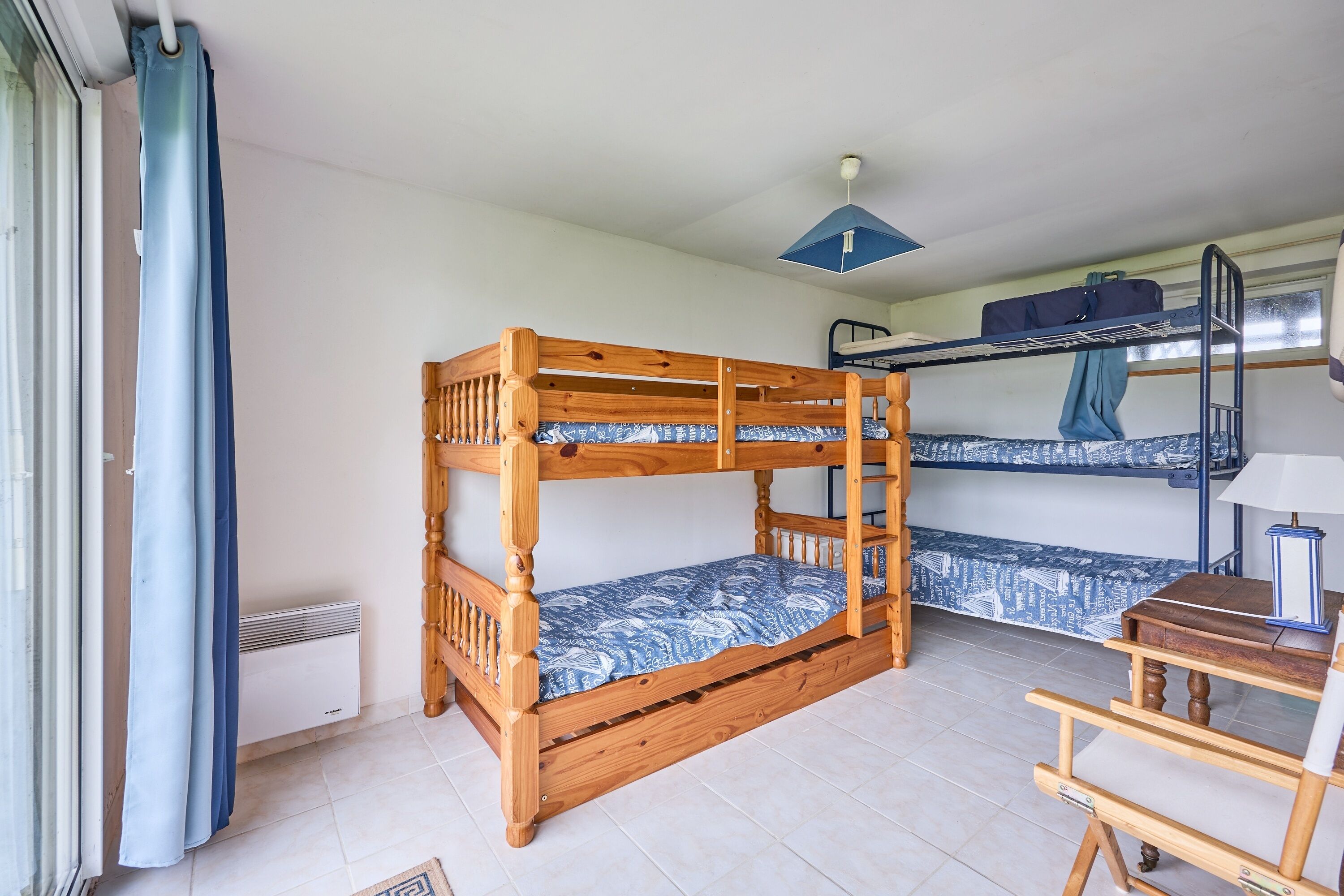 A bunk bed room with a wooden bed, a desk, and a radiator.
