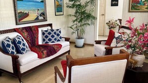 A living room with a sofa, armchairs, a potted plant, and artwork on the walls. - CLASSIC 1970'S STYLE HOUSE NEXT TO THE BEACH (Rio San Juan)