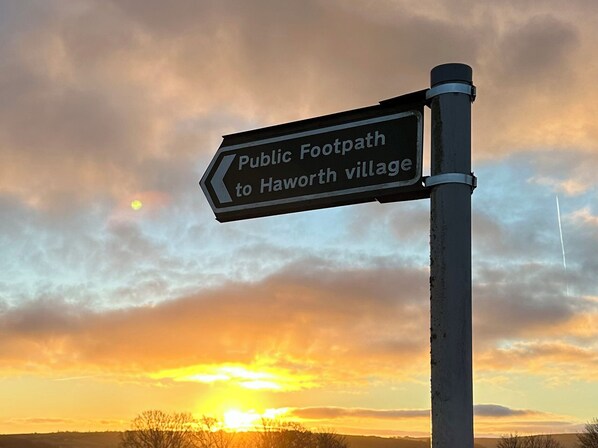 A directional sign for a public footpath to Haworth village. - Heathcliff Cottage (Keighley)