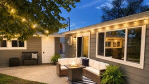 A house with a covered patio, outdoor seating, and a fire pit.