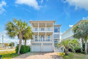 A two-story building with a balcony, a garage, and palm trees. - Curacao (Miramar Beach)