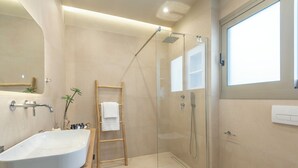 Ein modernes Badezimmer mit freistehender Waschtisch, einer Duschkabine und einer Toilette.