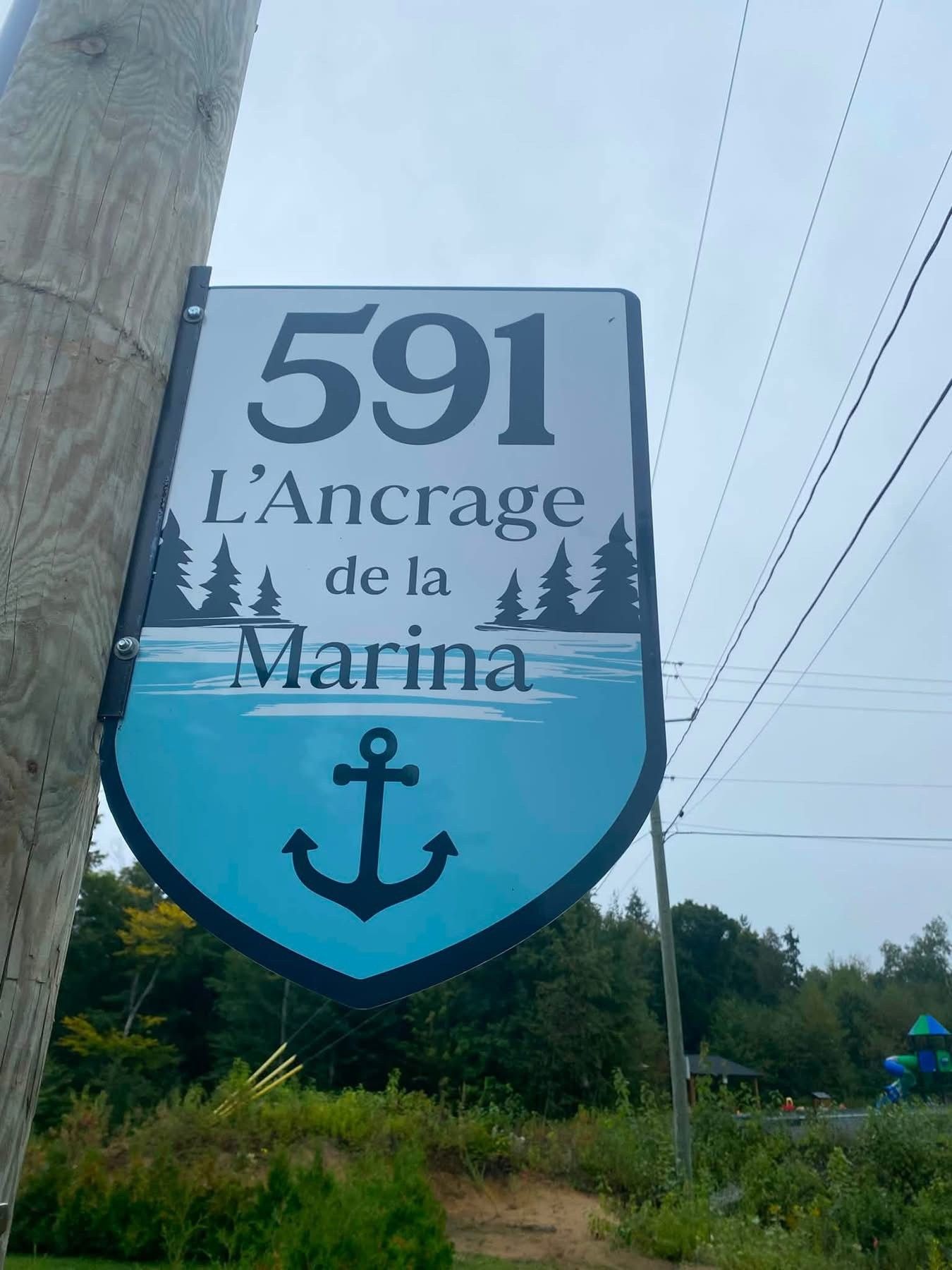 Un cartel con el número 591 y el texto 'L'Ancrage de la Marina', con un símbolo de ancla debajo.