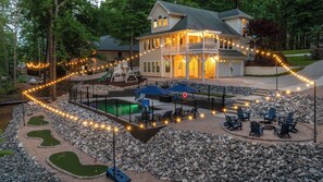 Ein Haus mit Pool, Liegestühlen und Lichterkette.