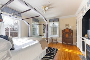 A bedroom with a four-poster bed, a wooden dresser, and a fireplace. - Miss Murphy's High Street Inn (Galena)