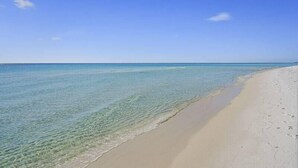 A beach with clear shallow waters and a sandy shore. - A Summer Lovin (Destin)