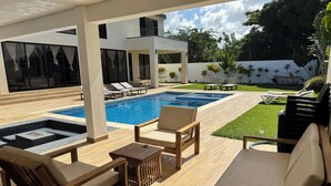 A poolside area with lounge chairs, a small table, and a fire pit. - 5-bedroom Luxury villa located  in Macao Beach,Punta Cana Dominican republic (Punta Cana)