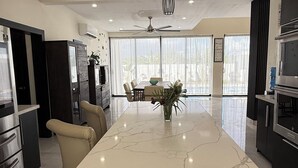 A modern kitchen with a marble island, built-in appliances, and a dining area with a view. - 5-bedroom Luxury villa located  in Macao Beach,Punta Cana Dominican republic (Punta Cana)