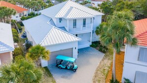 A two-story house with a garage, a covered driveway, and a golf cart parked in front. - Bonaire (Destin)