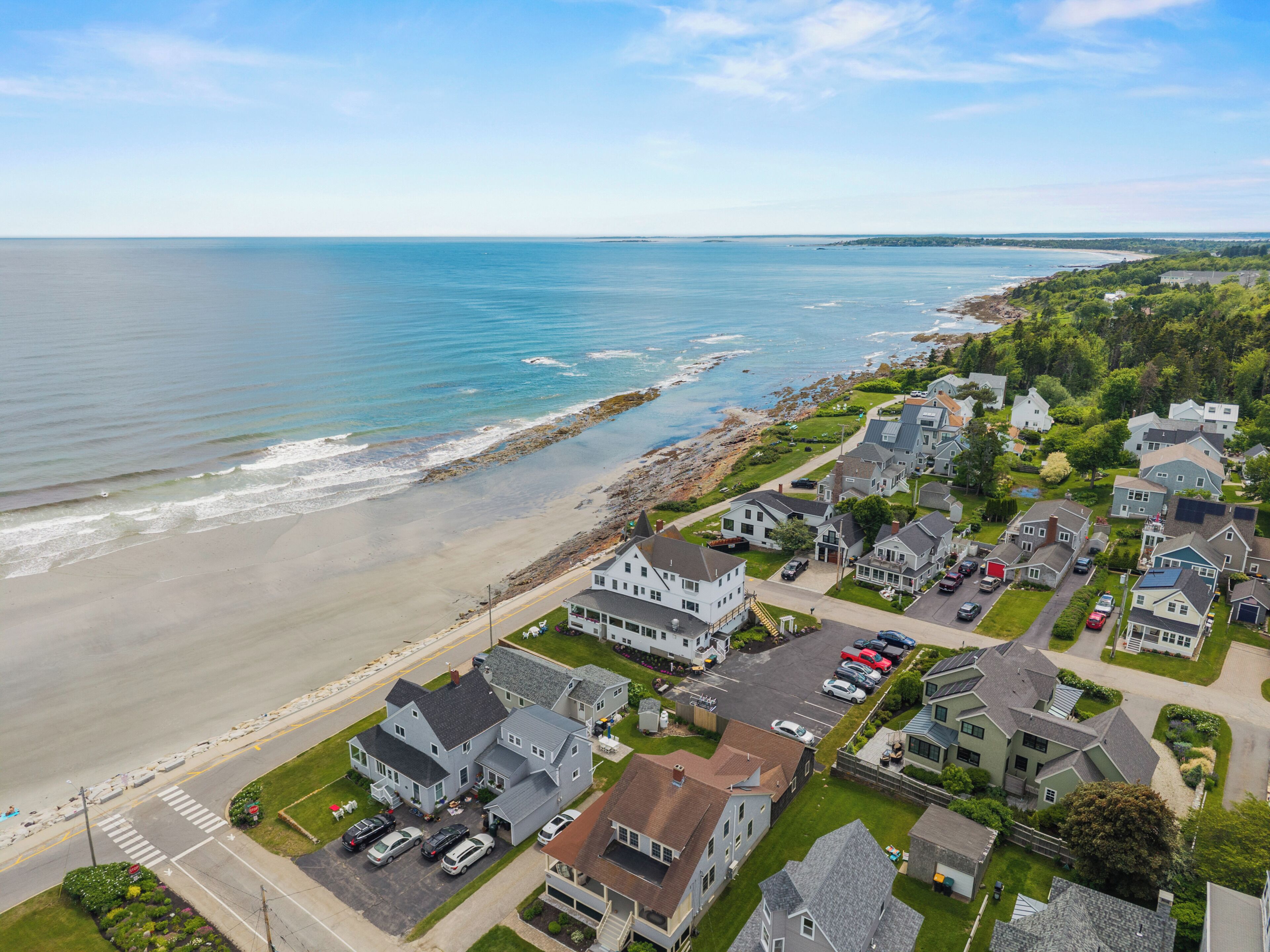 A coastal residential area with houses, a beach, and a view of the ocean.
