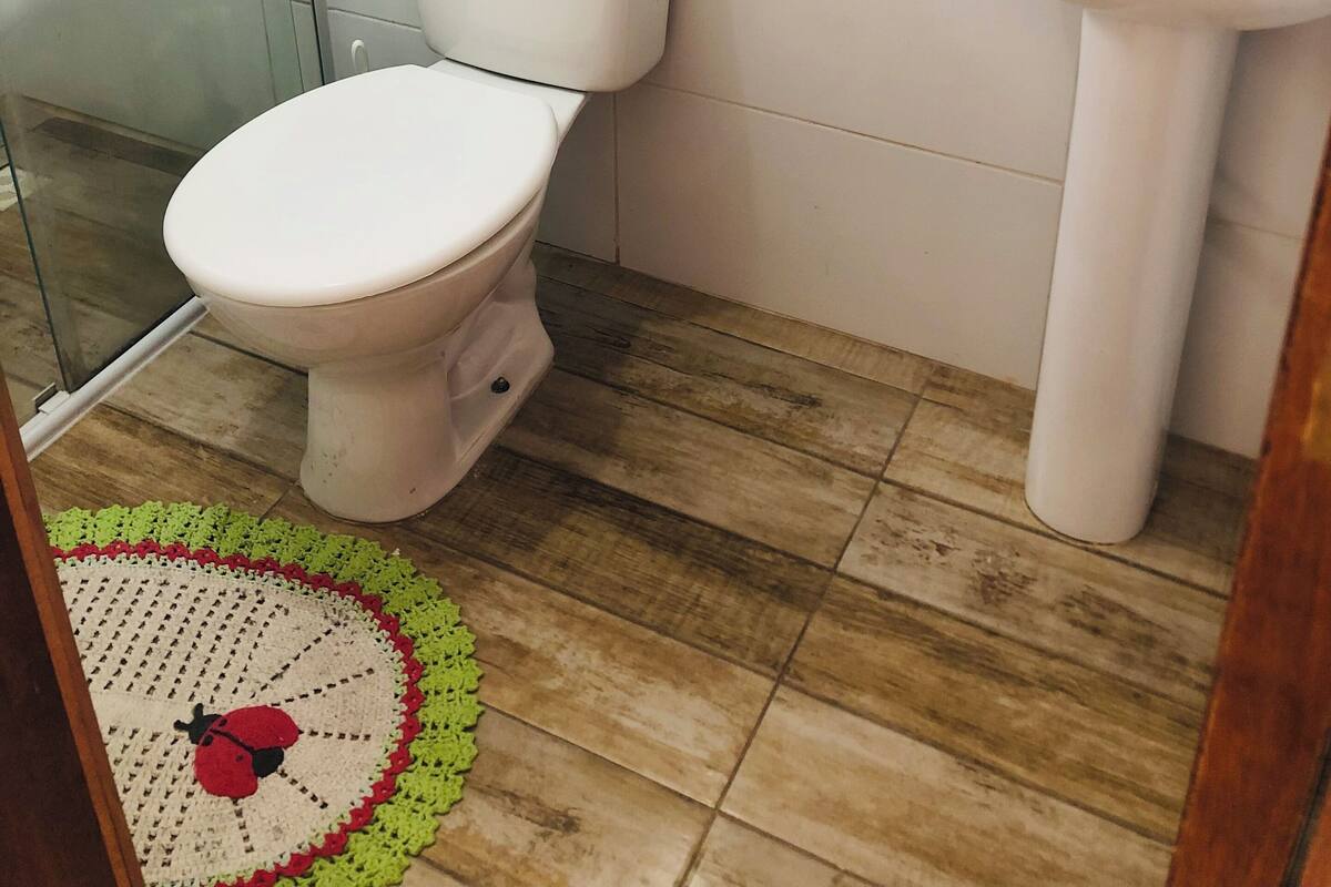 A bathroom with a toilet, sink, and glass shower enclosure.