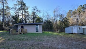 A single-story house with a front deck, a small porch, and a fenced yard. - Private Suite | Comfortable, Quiet & Well-Equipped (Augusta)
