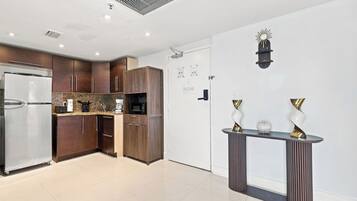 Cozinha moderna com geladeira, micro-ondas e armários de madeira.