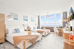 A hotel room with two beds, a desk, a chair, a TV, and a large window with a view. - Boutique Apartments Castle Beach (Miami Beach)
