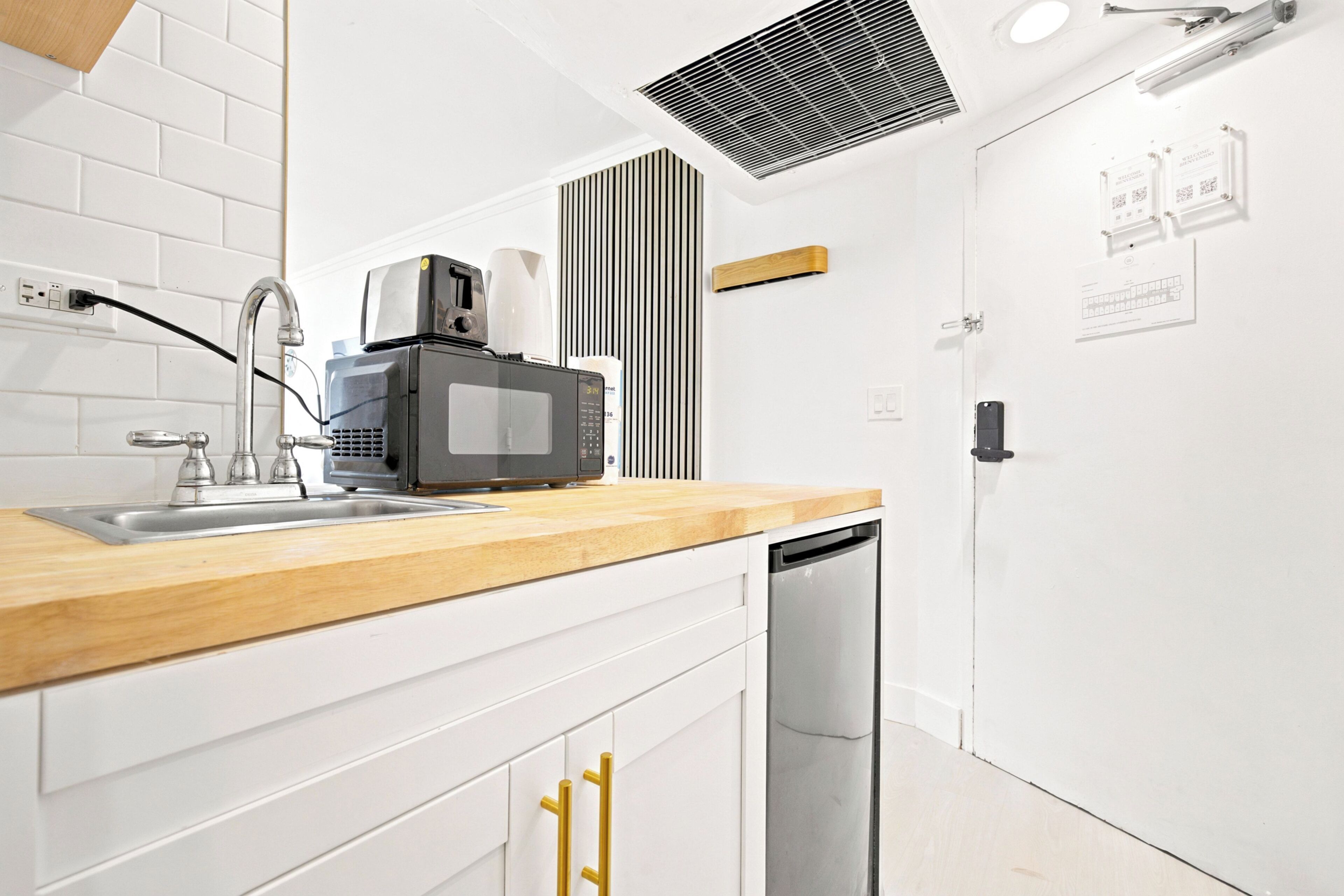 Una cocina moderna con encimera de madera, electrodomésticos de acero inoxidable y lavavajillas.