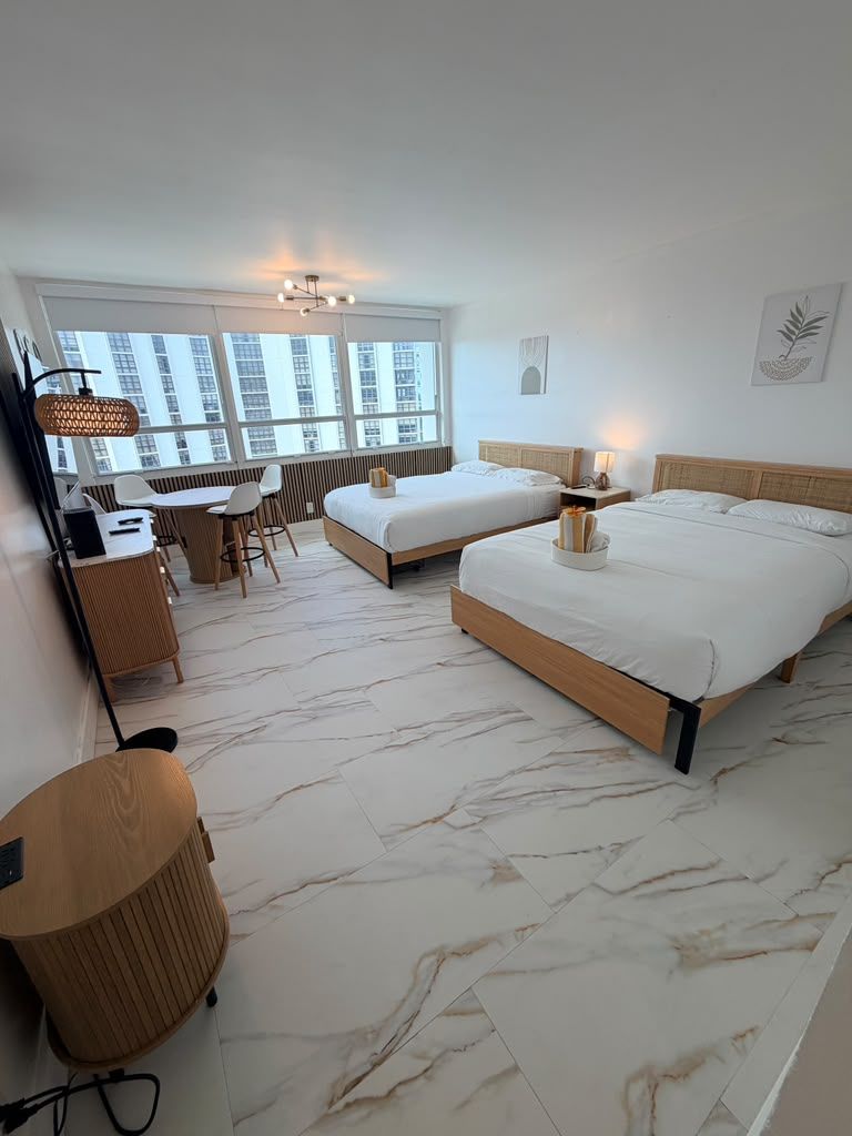 A modern hotel room with a large bed, a desk, and a chair.