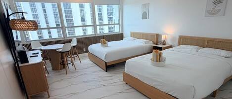 Quarto de hotel moderno com uma cama grande, uma escrivaninha e uma cadeira.