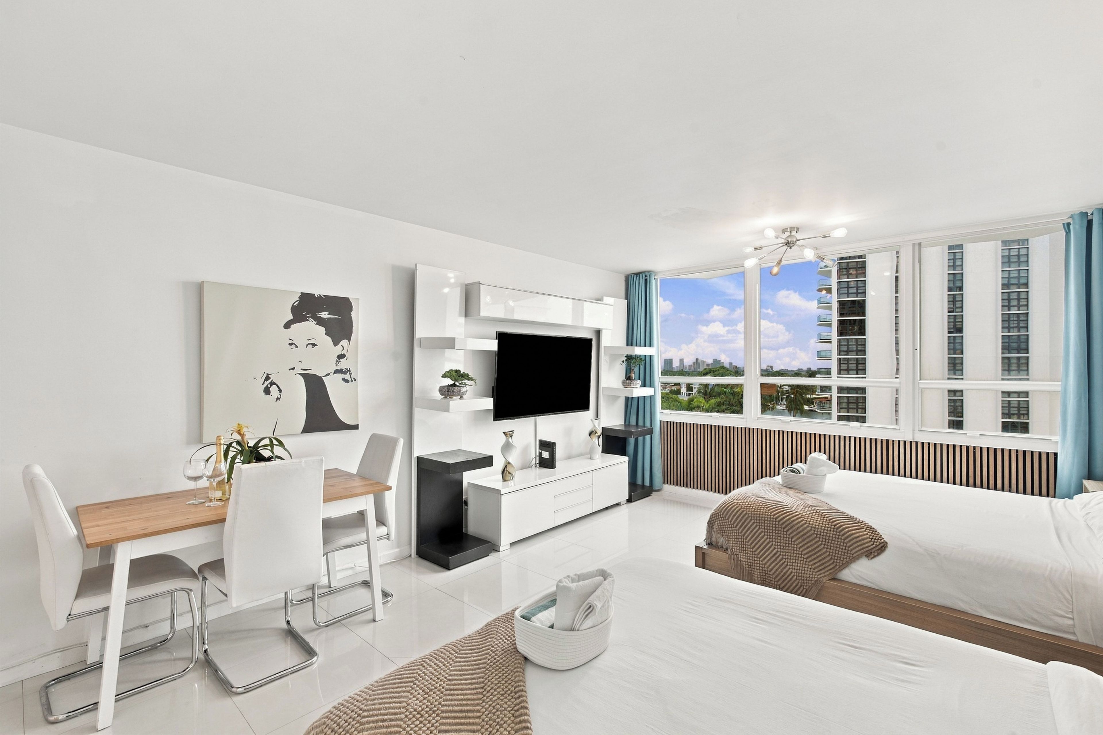 A modern living room with a dining area, a flat-screen TV, and a large window with a city view.