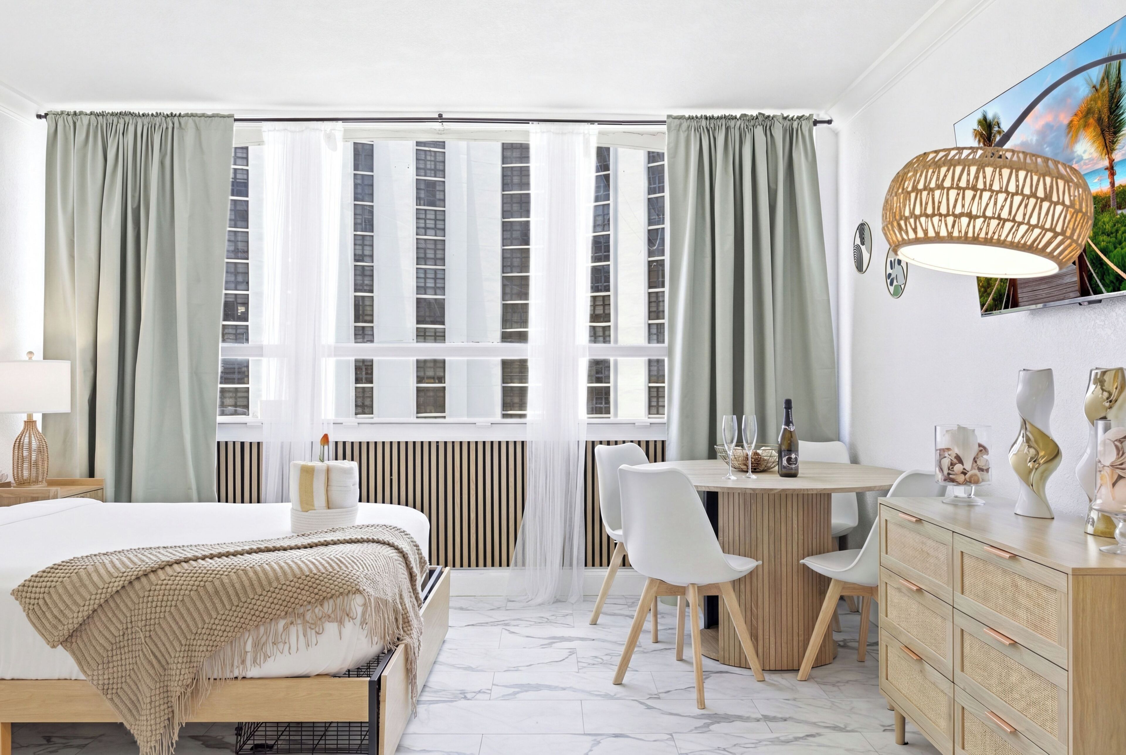 Ein modernes Hotelzimmer mit Bett, Esstisch und Sitzecke.
