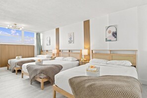 A hotel room with three beds, a large window, and a view of the sky. - Boutique Apartments Castle Beach (Miami Beach)